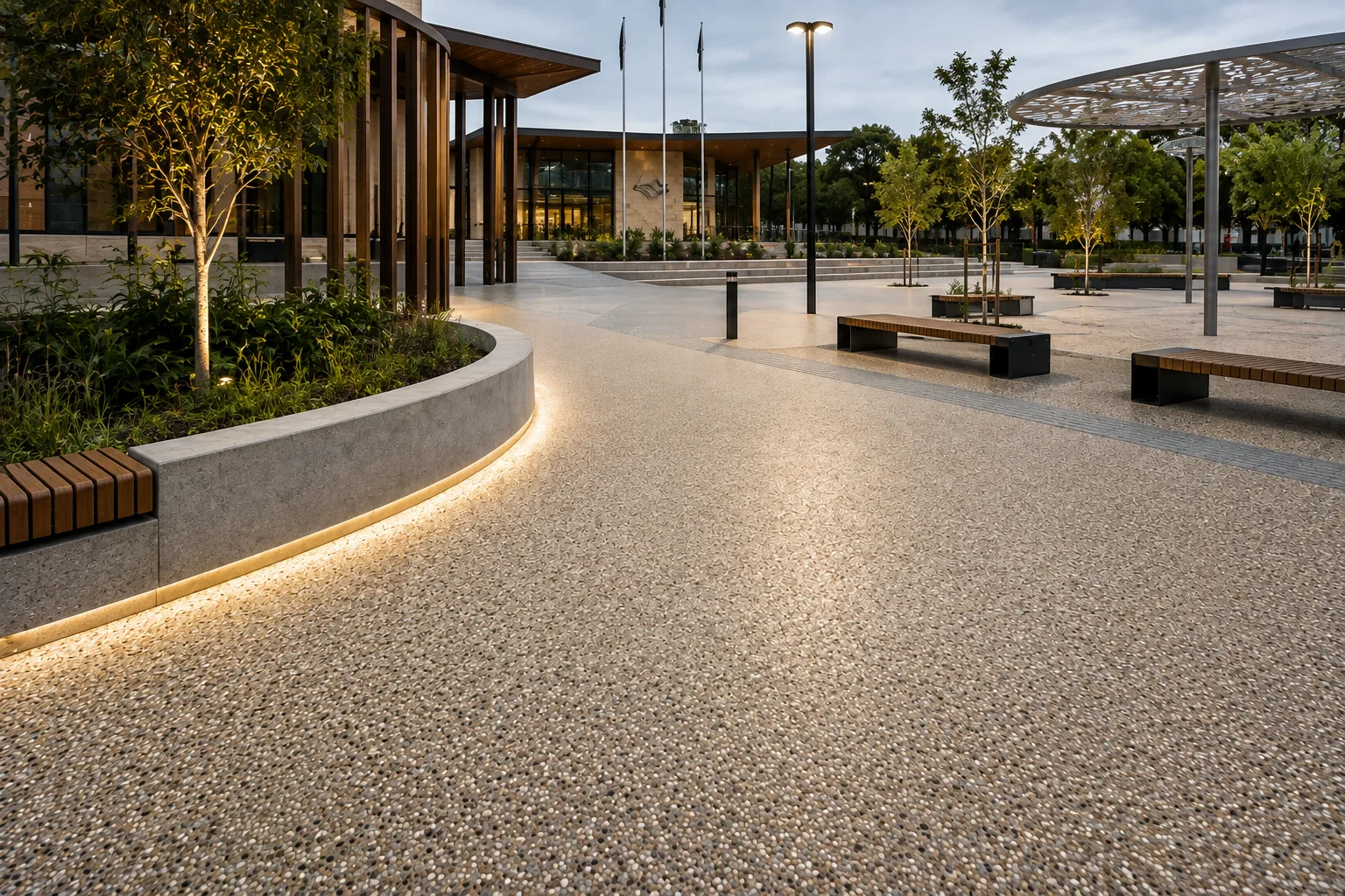 Resin bound paving across a civil plaza, with seating, street trees and a public building entrance beyond