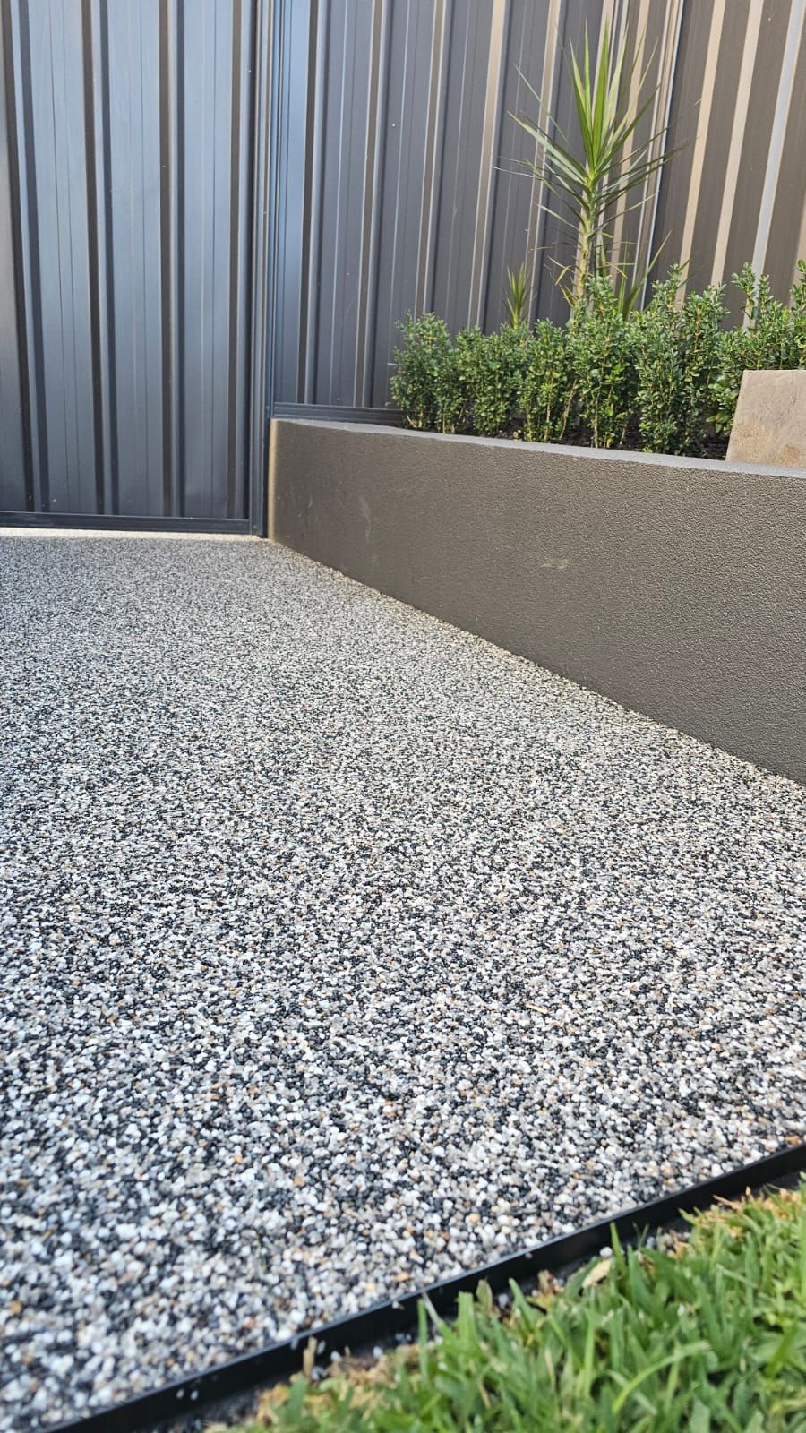 Close-up of the Dolomite aggregate finish against the garden bed edge