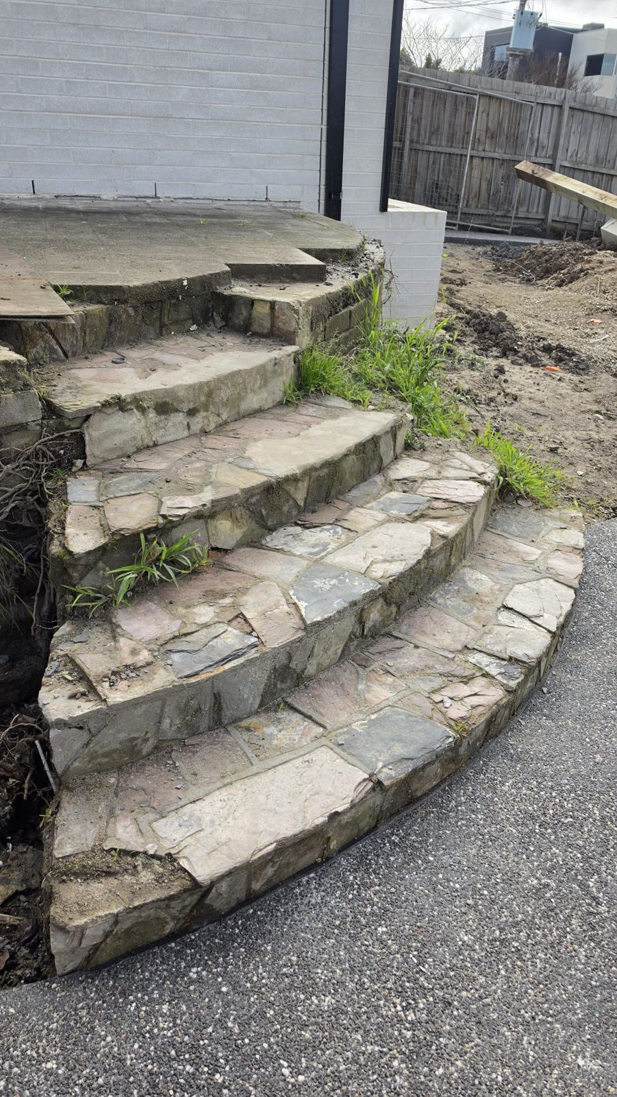 Old cracked crazy-paved curved steps before resurfacing